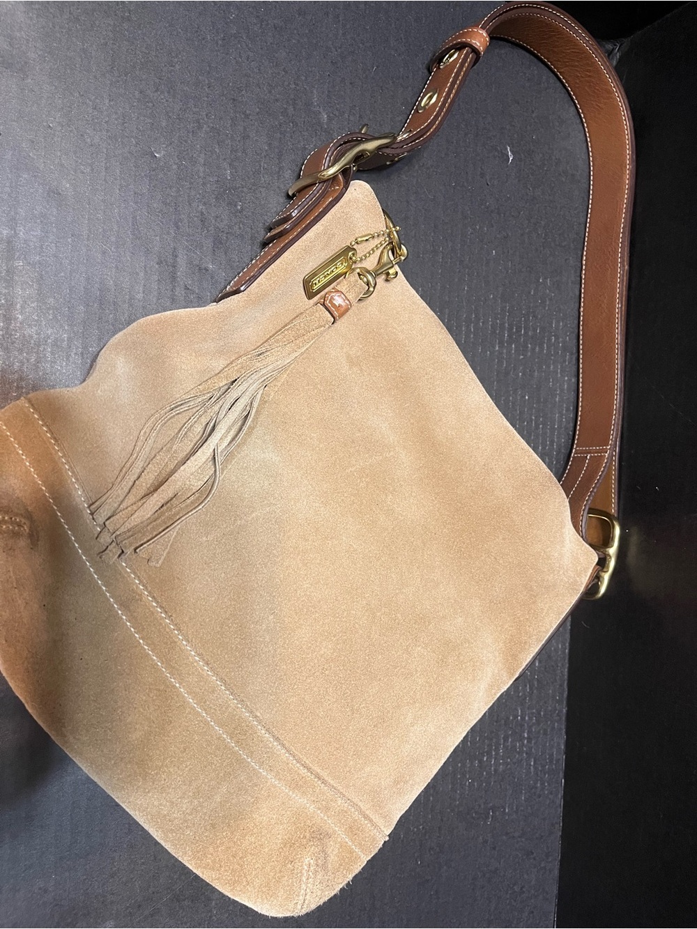 Cream/ tan suede Coach purse with tassel and signature lining Metal hang tag